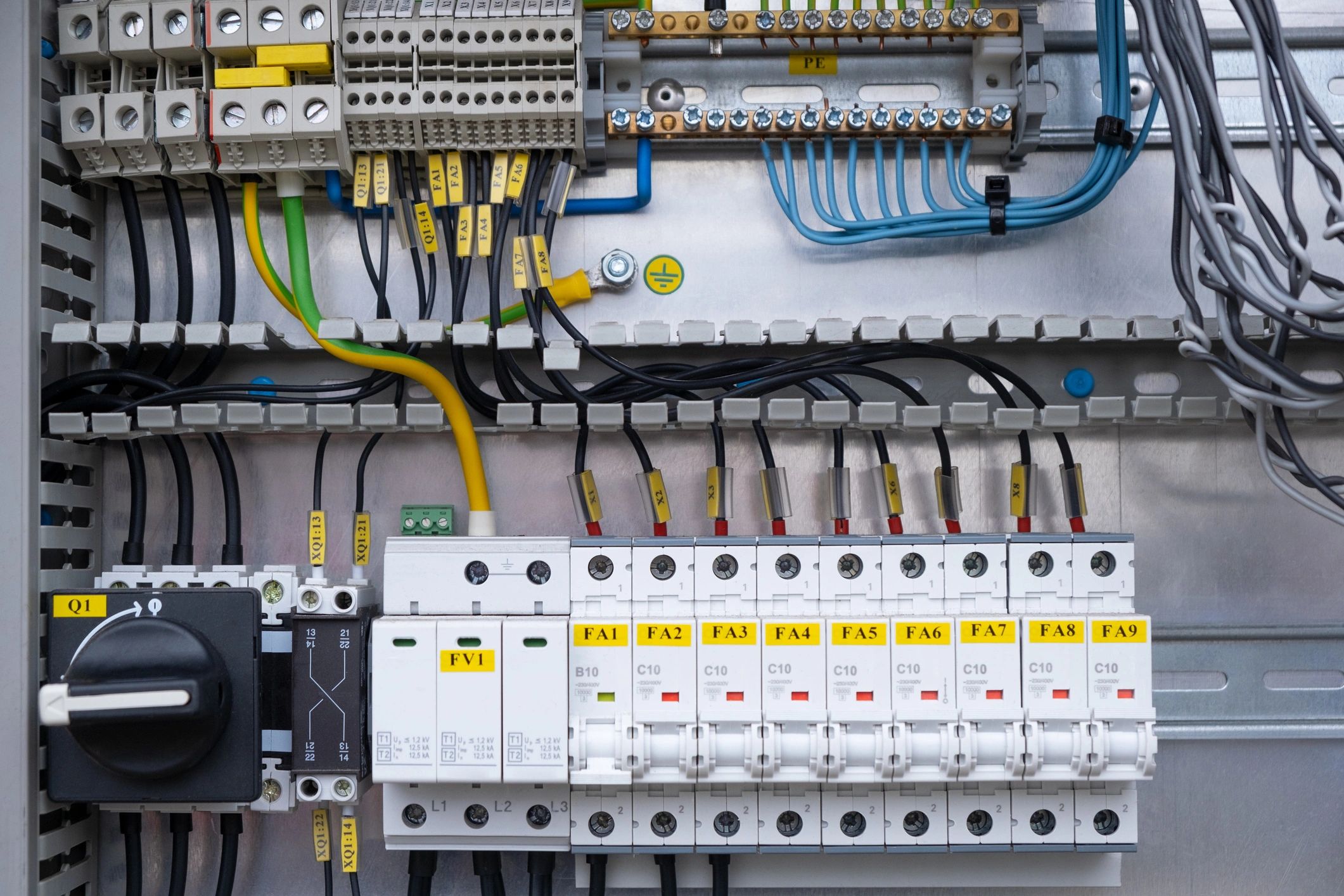 Electrical switchboard distribution box with different colored wires, switches and sensor circuit breakers for safety.