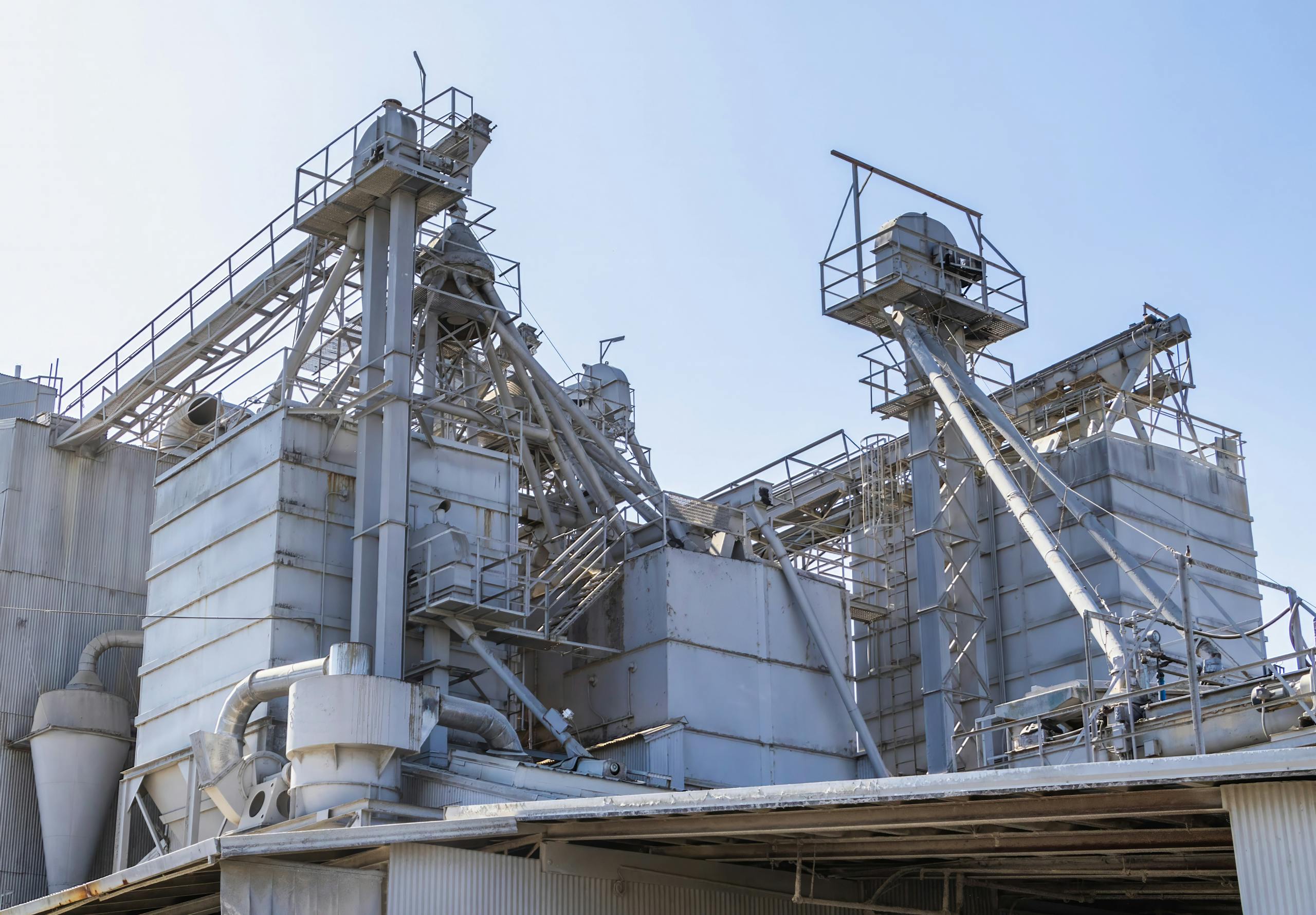 A complex industrial architecture of a cement factory showing metal structures and technology.